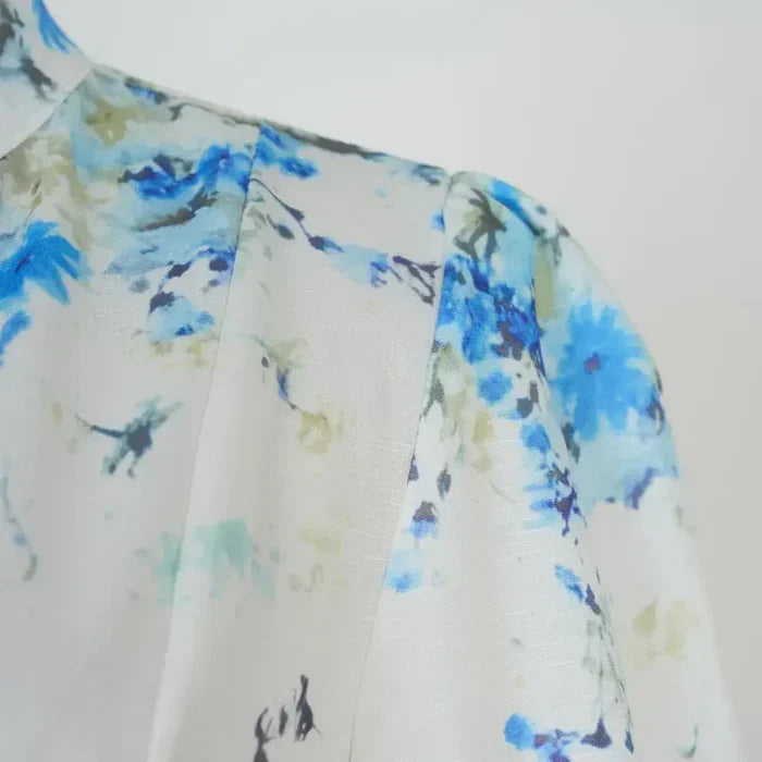 Amelia – Tidløs elegance i blomsterblå med høj hals